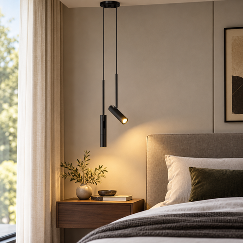 Adjustable black cylinder LED pendant beside a bed in a softly lit modern bedroom
