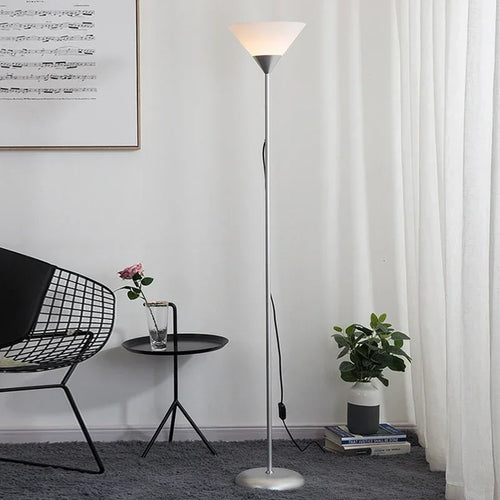 Silver uplighter floor lamp beside a chair
