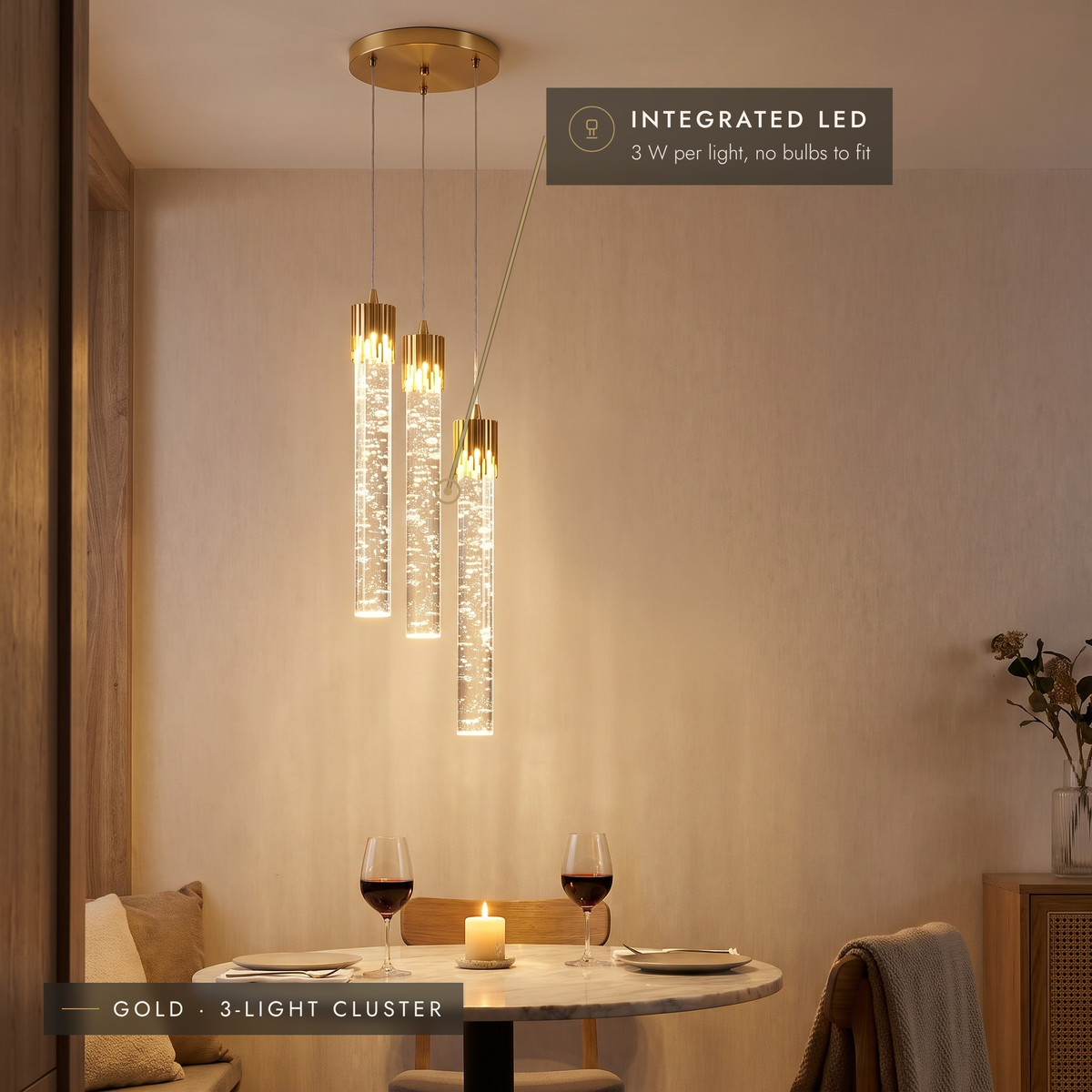 Gold three-light bubble tube cluster pendant above a dining table