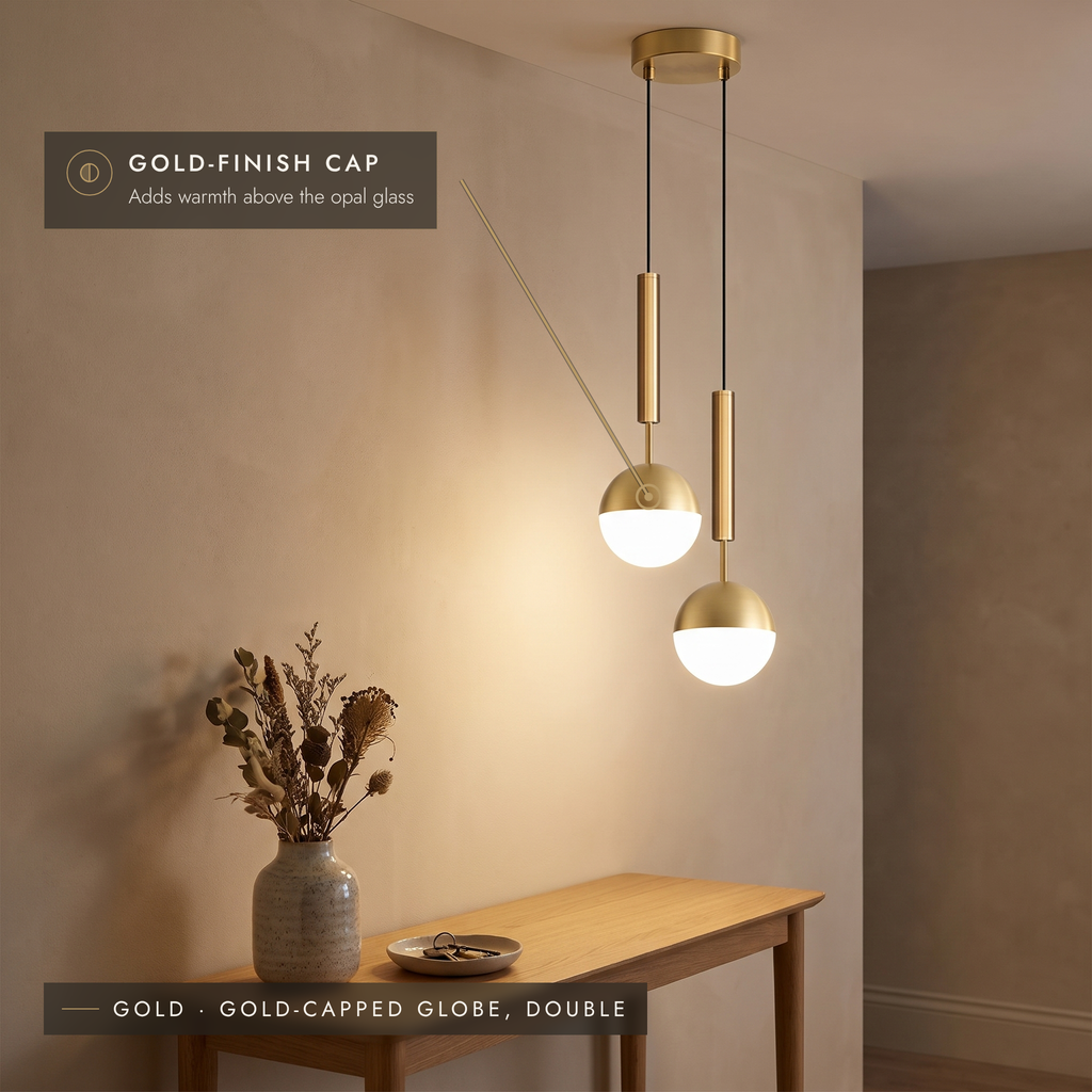 Double gold-capped globe pendant light above a console table