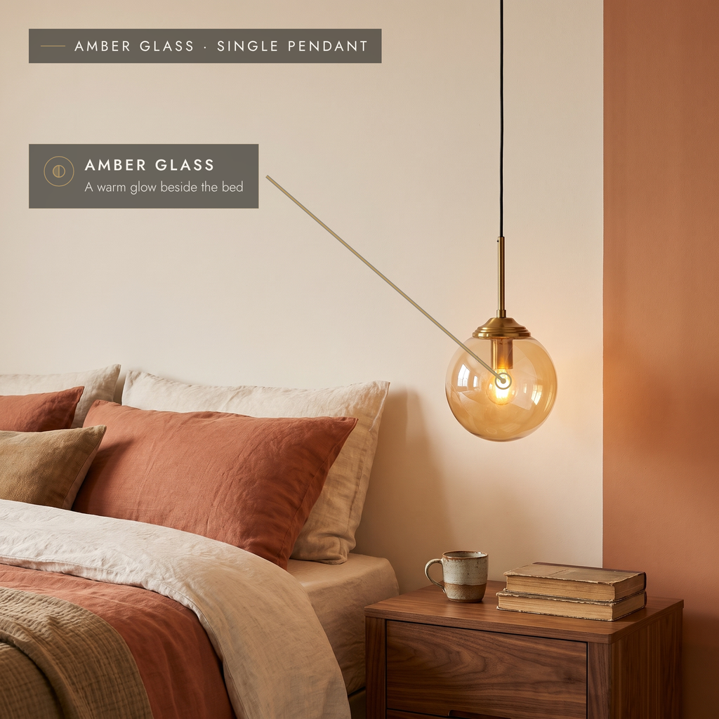 Amber glass globe pendant light beside a bed