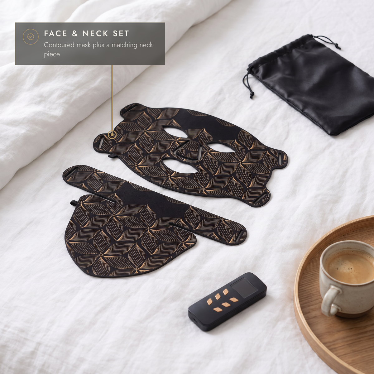 Flexible black and gold LED face and neck mask on white linen with controller and storage bag
