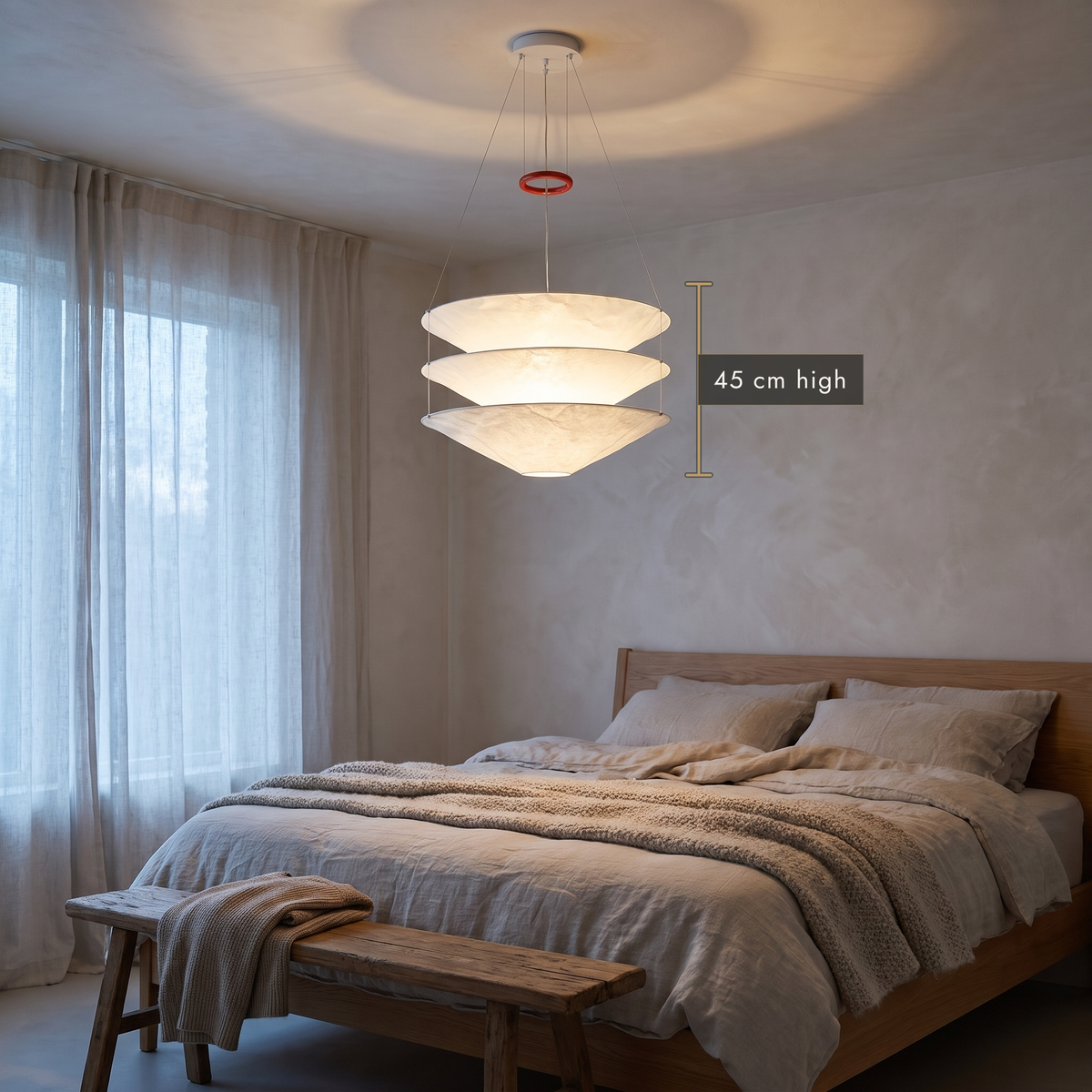 Layered paper pendant chandelier in a calm bedroom with linen bedding