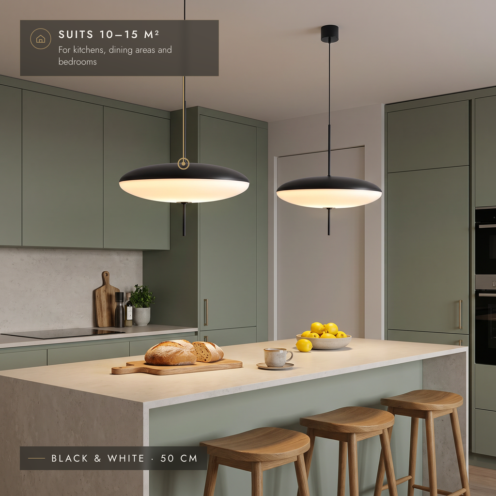 Two black and white disc pendant lights above a sage green kitchen island