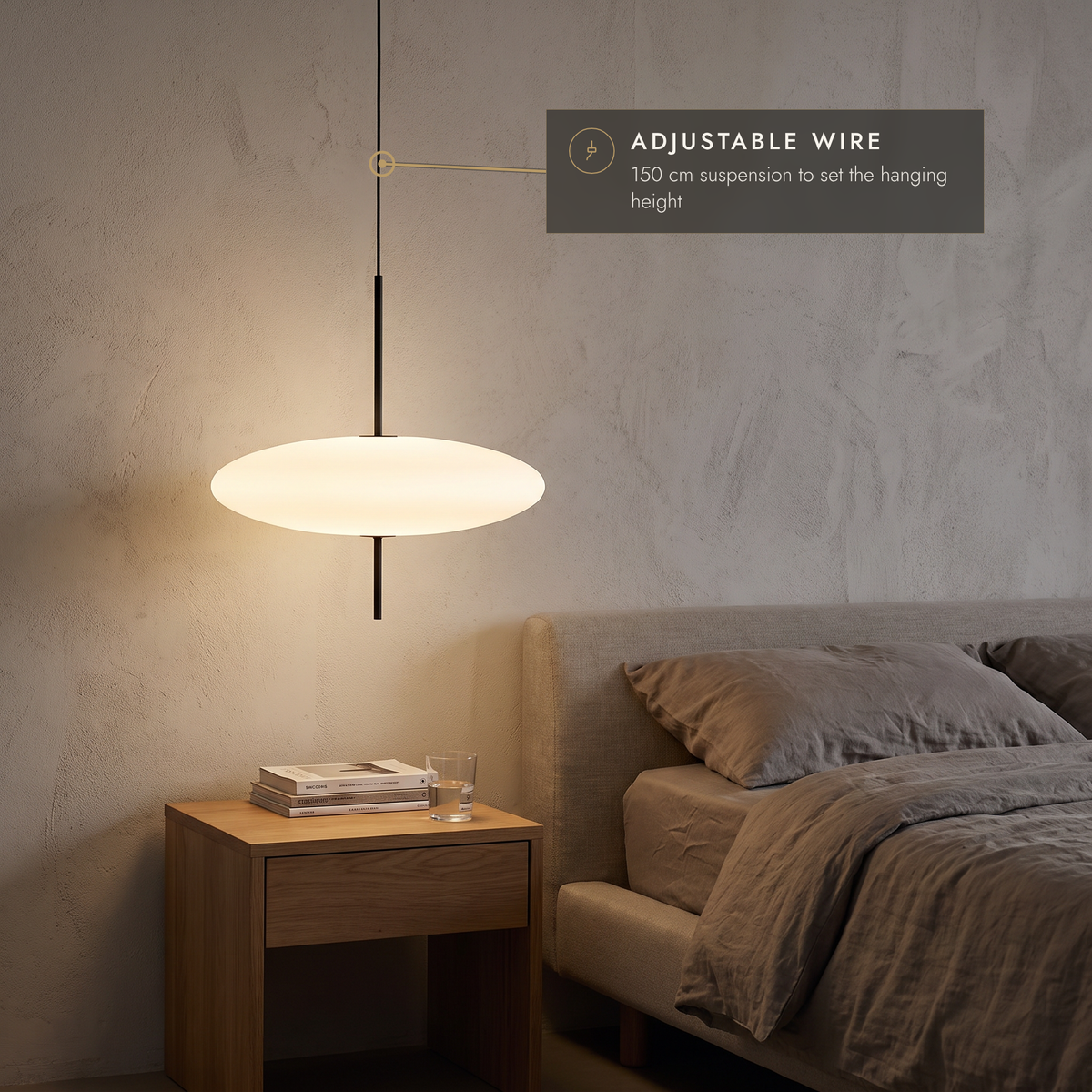 White disc pendant hanging low as a bedside light in a calm bedroom