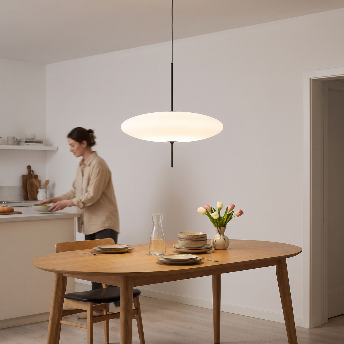 White 50 cm disc pendant light above an oval oak dining table