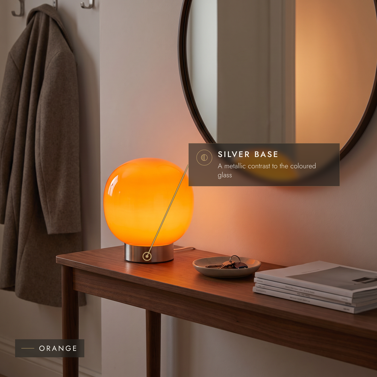 Orange glass globe lamp on a walnut console table in an entrance hall