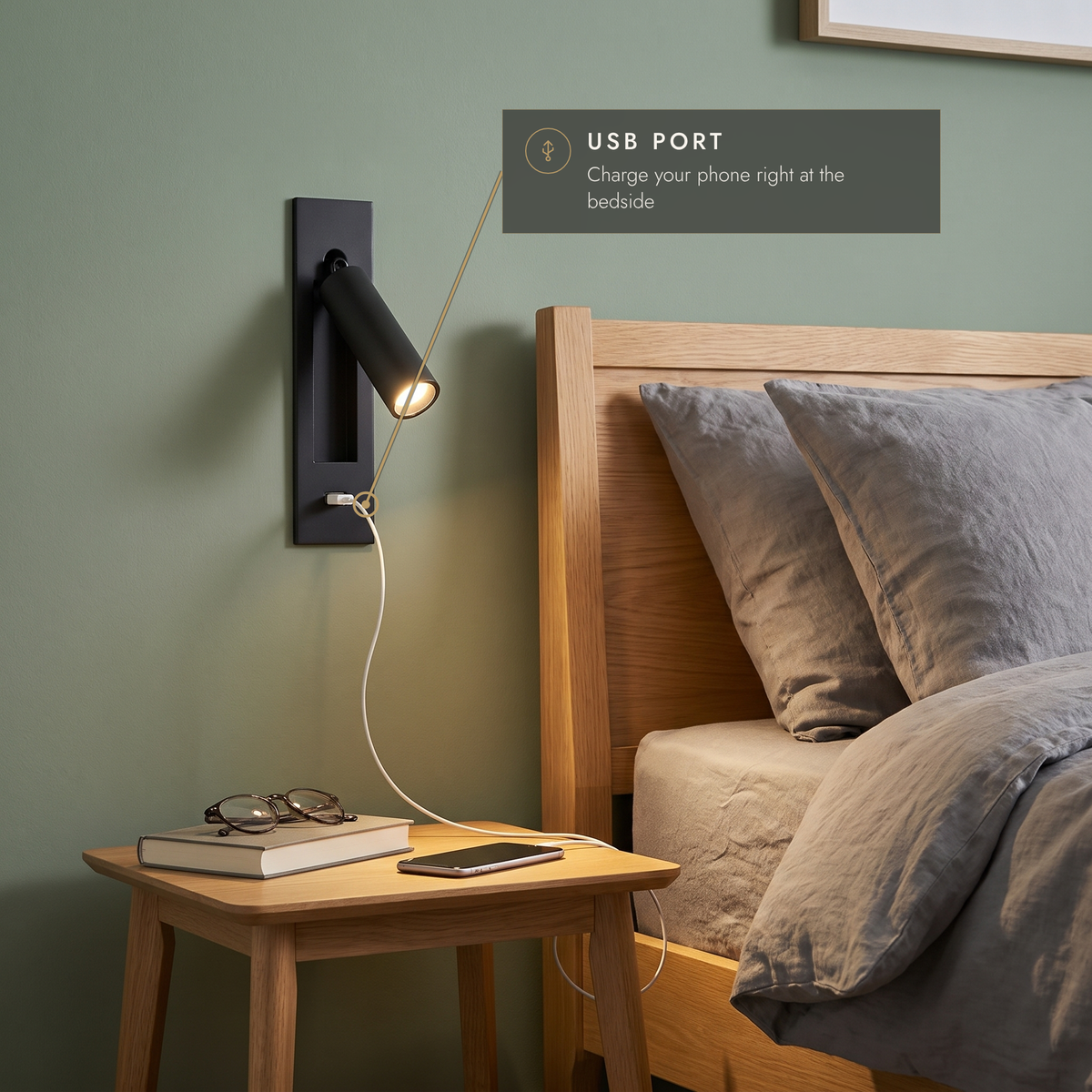 Black wall reading light with USB port charging a phone on the bedside table