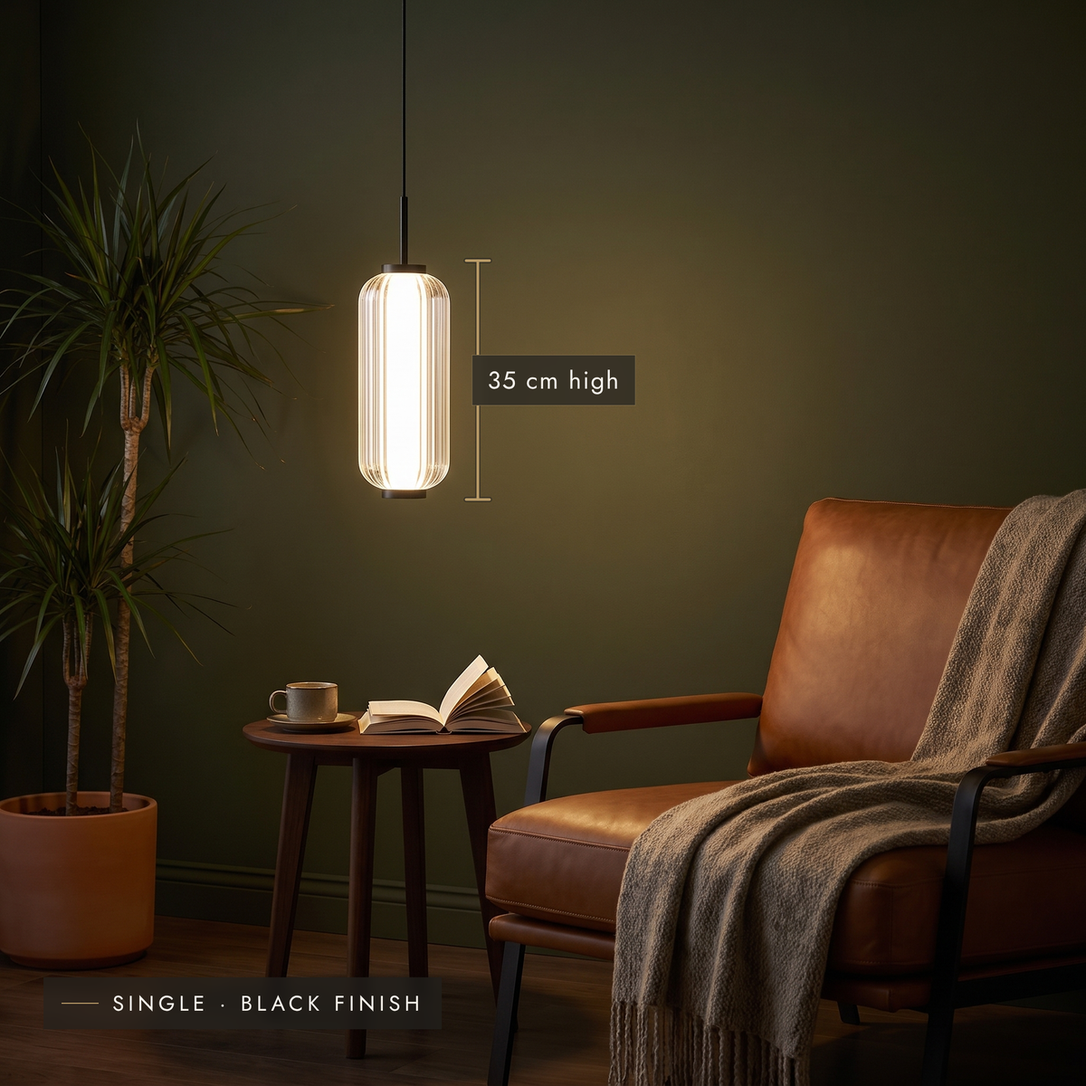 Single ribbed LED pendant with black finish beside a leather lounge chair