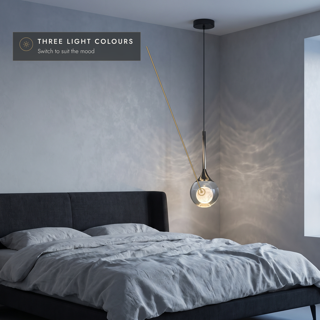 Teardrop pendant light with round flat canopy above a bed in three light colours