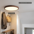 Walnut-effect ultra-thin LED ceiling light, 30 cm diameter, in a hallway